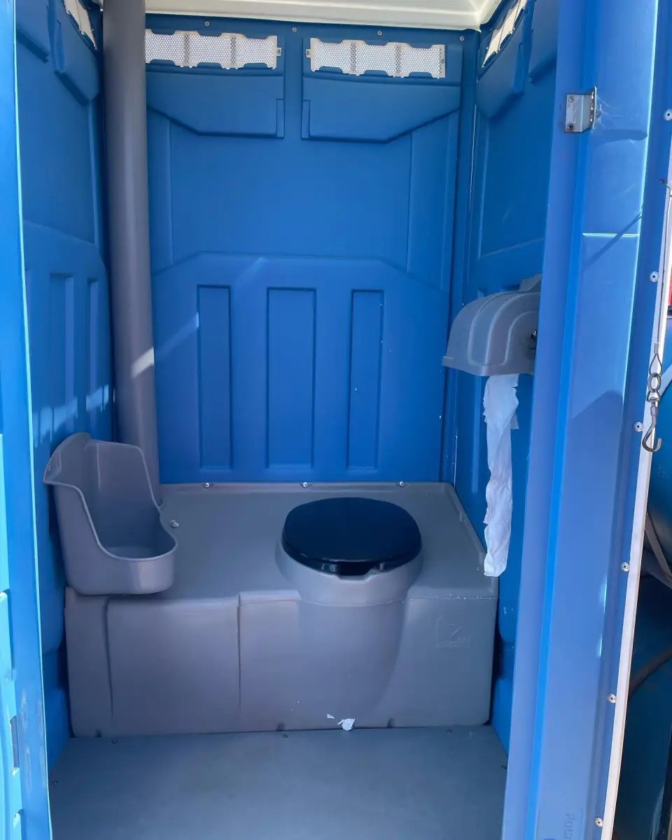Interior of a portable restroom with toilet and urinal